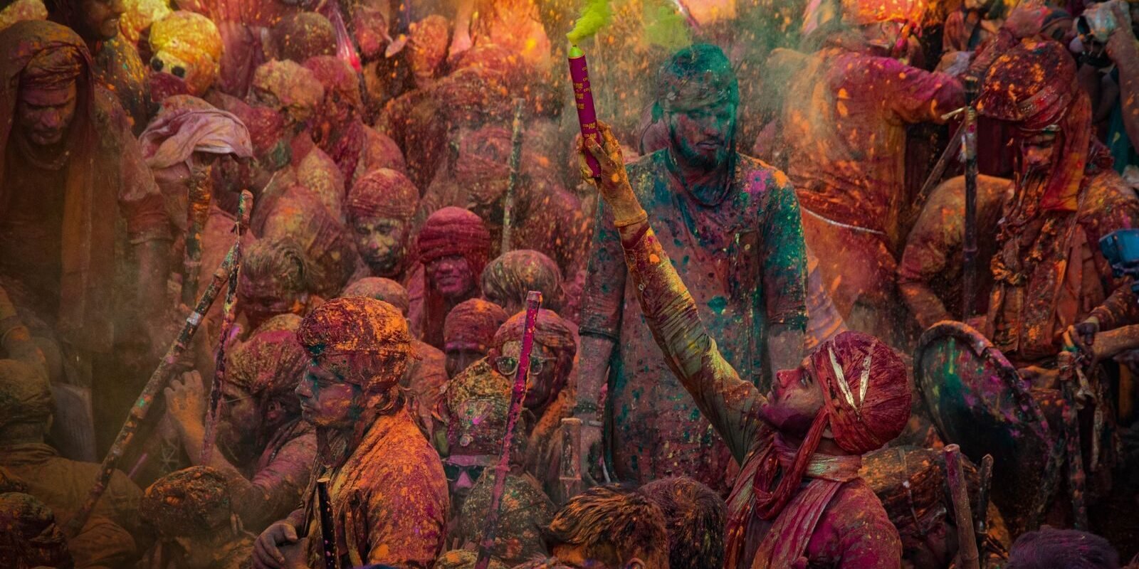 Colorful Holi festival with celebrating crowd in Mathura, India.