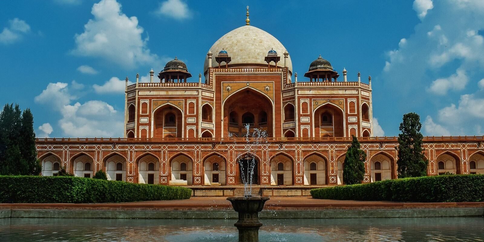 A beautiful view of Humayun's Tomb in New Delhi, showcasing its Mughal architecture and reflecting pool.